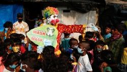 A clown raising awareness about Covid-19 among children in a slum in Mumbai, India.  