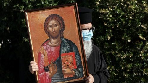 Ein orthodoxer Priester hält eine Ikone in der Hand