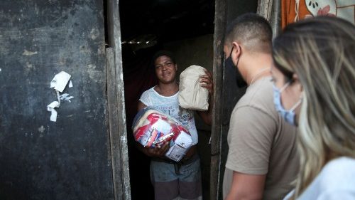 A woman in Rio de Janeiro , Brazil, receiving food aid from volunteers amid the pandemic.