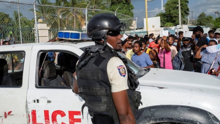 Haitian National Policemen guard the entrance to the U.S. Embassy as people gather to ask for asylum following the assassination of President Jovenel Moise