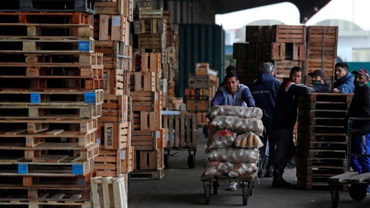 A man pushes a cart with bags of potatoes at the Mercado Central in Buenos Aires where he works earning the equivalent of 60 US dollars per month