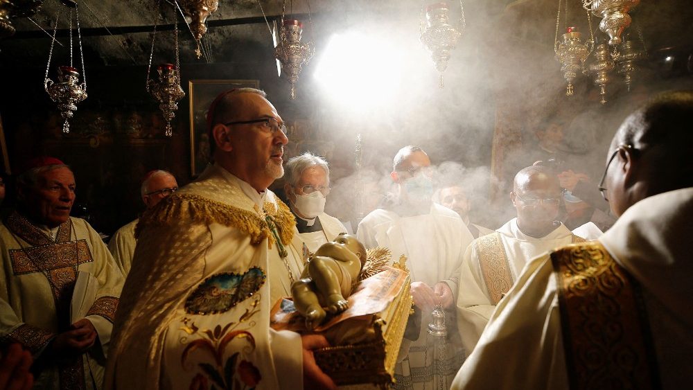 Patriarca Latino de Jerusalém com imagem do Menino Jesus na Gruta de Belém (Foto: Reuters/Mussa Qawasma/Pool)