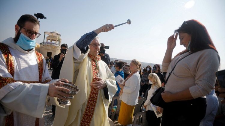 Fr. Francesco Patton, the Custos of the Holy Land, sprinkles holy water on a woman near the Jordan River
