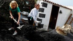 Sur l'île de La Palma, des habitants déblaient les cendres dans leur jardin, le 20 janvier 2022 