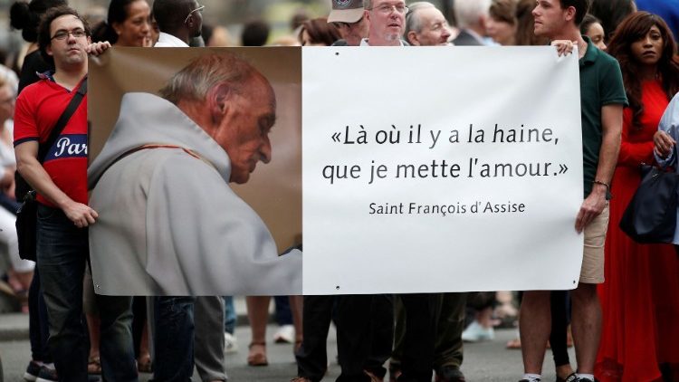 Des fidèles brandissent une affiche à l'issue de la messe d'hommage au père Jacques Hamel, à la cathédrale Notre-Dame de Paris, le 27 juillet 2016. (Benoit Tessier/Reuters)