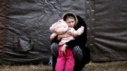 러시아의 침공을 피해 이동한 한 여성이 폴란드 프세미시우 난민캠프에서 아이를 껴안고 있다.