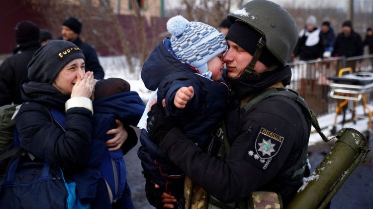 A Ukrainian police officer hugs his son before leaving to fight the Russian invasion