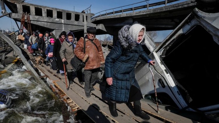 Un gruppo di persone fugge da Irpin, dopo i bombardamenti russi .