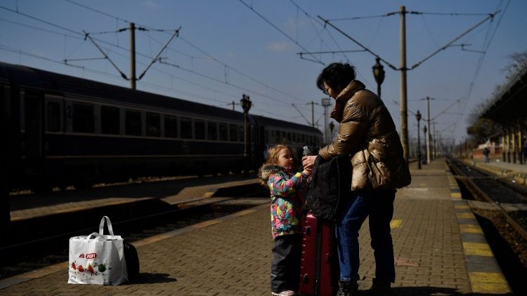 रूस के आक्रमण से भागे लोग यूक्रेन के सुसेवा ट्रेन स्टेशन पर पहुंचे