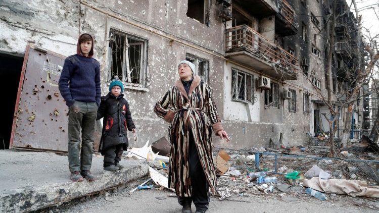 Família Bykovets diante de prédio bombardeado em Mariupol (Reuters/Alexander Ermochenko)