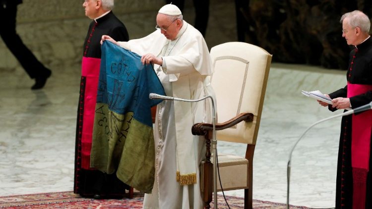 Pope Francis holds a Ukrainian flag that came from Bucha