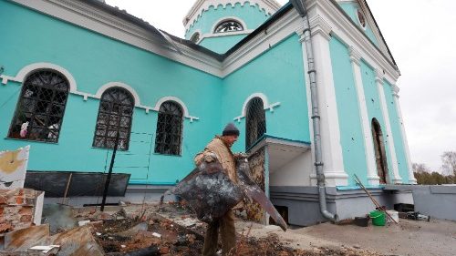 A man removes debris outside an orthodox church building damaged by Russian shelling in Chernihiv