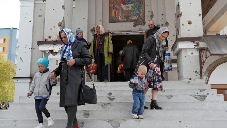 Věřící vycházejí z kostela Svaté Trojice po pravoslavné velikonoční bohoslužbě v přístavním městě Mariupol na jihu Ukrajiny 24. dubna 2022