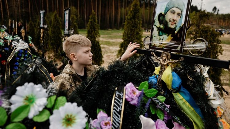Savelli, 10 anos, no túmulo de seu pai Ihor, de 47, no cemitério de Irpin, região de Kiev. REUTERS/Zohra Bensemra