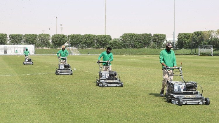 Des employés tondant le gazon d'un stade d'entraînement à Doha, le 30 mai. 