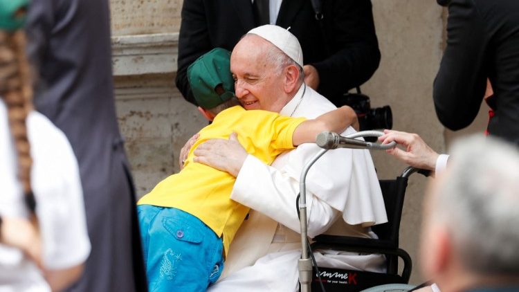 Papst Franziskus umarmt ein ukrainisches Kind, das vor dem Krieg in der Ukraine geflohen ist