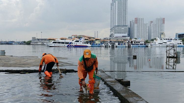 Des employés indonésiens collectent des déchets du port de Muara Angke, à Jakarta, le 8 juin 2022. 