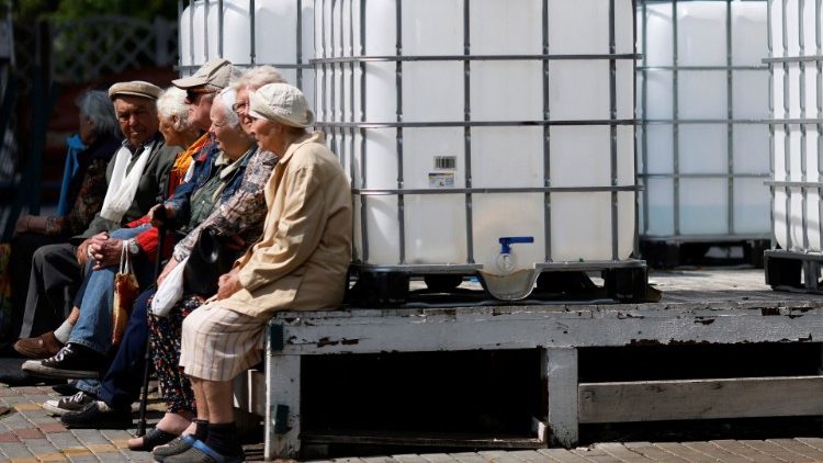 Residentes idosos esperam ao lado de recipientes de água vazios para coletar ajuda humanitária em um ponto de distribuição da Cruz Vermelha, enquanto os ataques da Rússia à Ucrânia continuam, em Mykolaiv, Ucrânia 10 de junho de 2022. REUTERS/Edgar Su