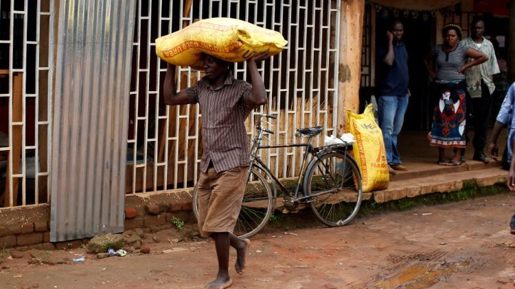 Ein malawischer Arbeiter trägt einen Sack Dünger