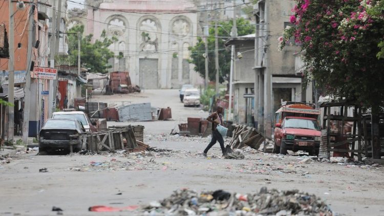 A man walks between road blocks set up by gangs in Haitian capital Port-au-Prince