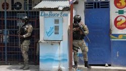 Members of the Haitian National Police patrol a street as gun battles between gangs continue. 