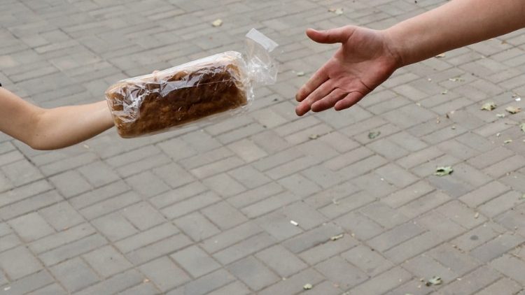Voluntário humanitário ucraniano dá pão a uma pessoa durante distribuição de ajuda humanitária, durante a evacuação de áreas afetadas pela guerra no leste da Ucrânia, enquanto o ataque da Rússia à Ucrânia continua, em Bakhmut, Ucrânia 26 de agosto de 2022. REUTERS/Ammar Awad