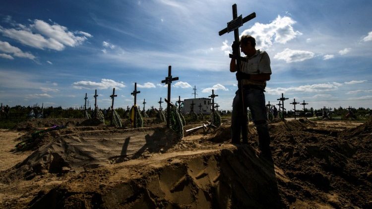 Crosses are planted over the graves of unidentified war victims in Bucha, near Kyiv