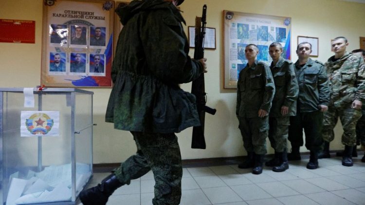 Service members of the self-proclaimed Luhansk People's Republic vote during a referendum in Luhansk