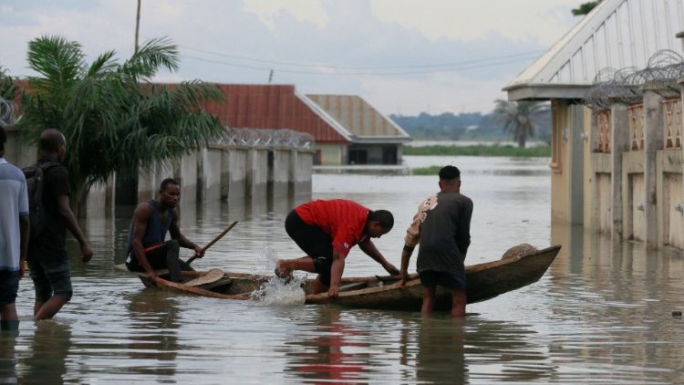 Flood-affected people enter a canoe on a flooded street close to the bank of Benue River in Makurdi