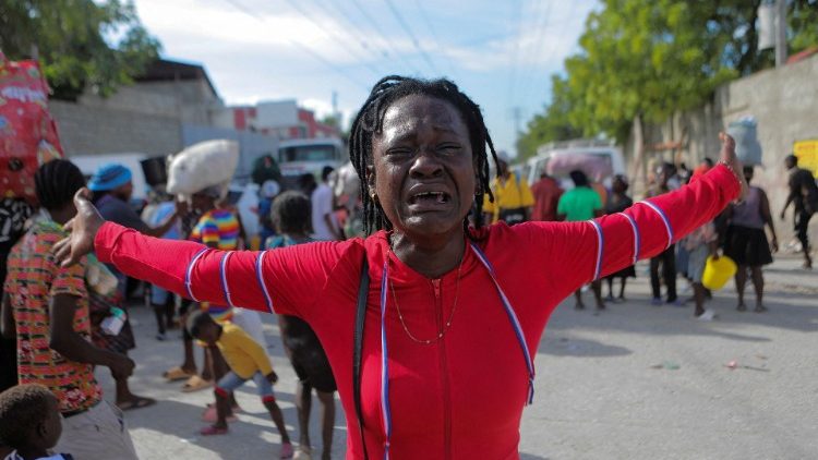 Rose chora enquanto pessoas deslocadas pela violência da guerra de gangues em Cité Soleil caminham pelas ruas do bairro de Delmas após deixarem a Praça Hugo Chaves, em Porto Príncipe. (REUTERS/Ralph Tedy Erol)