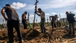 우크라이나 부차에서 자원봉사자들이 러시아군에 의해 희생된 민간인 사상자들이 묻혀 있는 무덤에 십자가를 꽂고 있다. 