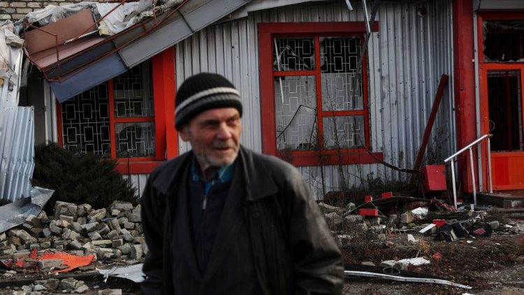 A man walks by a damaged building in the formerly Russian-occupied town of Lyman, Donetsk region