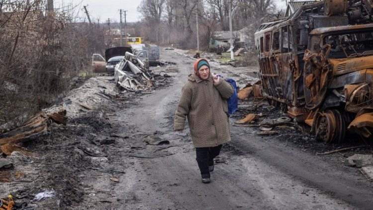 Un residente locale percorre una strada vuota vicino a veicoli distrutti, mentre continua l'attacco della Russia all'Ucraina, nel villaggio di Torske, regione di Donetsk, Ucraina 30 dicembre 2022. REUTERS/Yevhen Titov