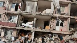 Pessoas olham em meio aos escombros enquanto a busca por sobreviventes continua após um terremoto em Hatay, Turquia, 7 de fevereiro de 2023. REUTERS/Umit Bektas
