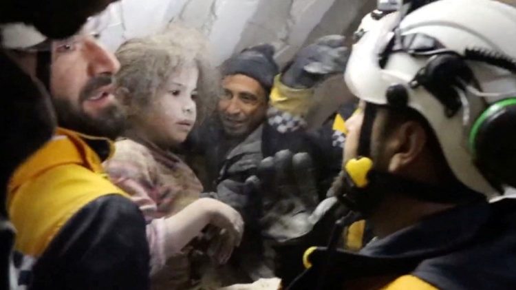 Os voluntários dos Capacetes Brancos seguram a criança após retirá-la dos escombros, após um terremoto mortal, em Jandaris, Síria, 8 de fevereiro de 2023. Capacetes Brancos/Divulgação via REUTERS