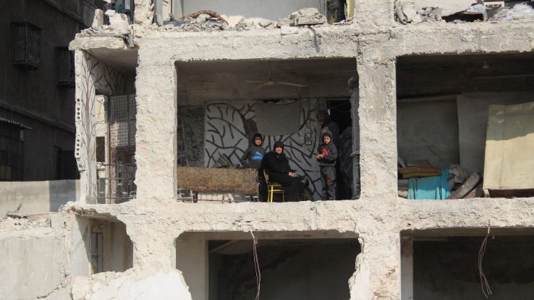 A Syrian family in their damaged home in Aleppo