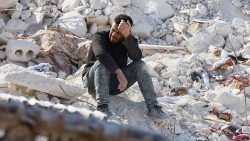 Un uomo, ad Idlib in Siria, siede sulle rovine dopo il sisma che ha colpito il Paese 