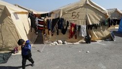 A child walks outside tents at a camp for earthquake survivors near Jandaris, Syria