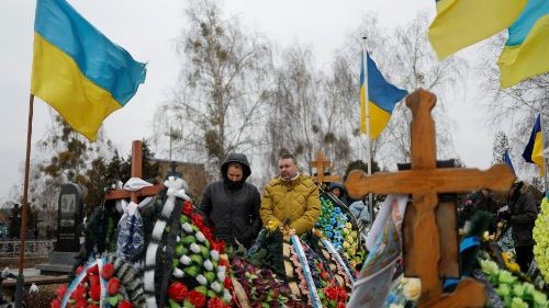 Ukrainian people visit graves of relatives in cemetery in town of Bucha, outside Kyiv.