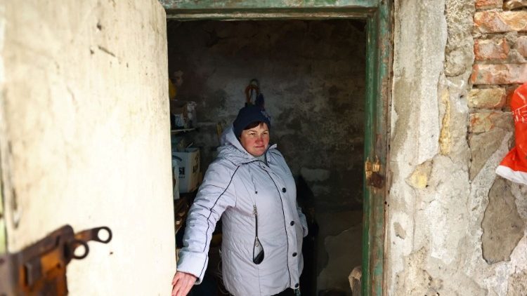 Svitlana Gynzhul, 55, stands at the entrance door of a former Soviet nuclear bunker, that has become her home for almost one year, as the village was located between front lines and devastated by shelling in the beginning of the war, amid Russia's invasion of Ukraine, in Luch, Mykolaiv region, Ukraine, February 24, 2023. REUTERS/Lisi Niesner