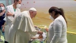 Pope Francis baptizes a baby during a visit to the children's cancer ward at Rome's Gemelli hospital