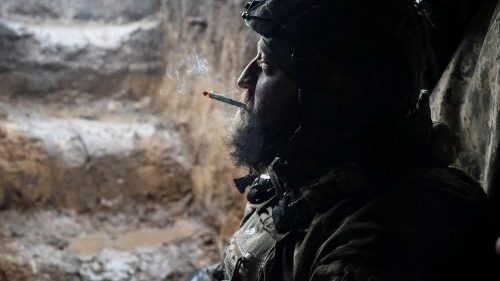 A Ukrainian service member smokes in a shelter at a front line near the city of Bakhmut
