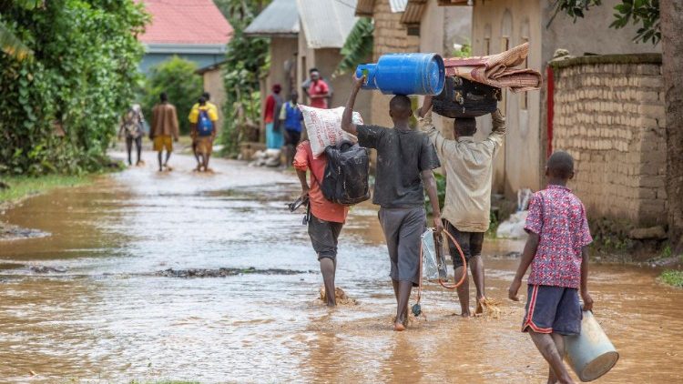 Pessoas desalojadas deixam suas casas após enchentes no distrito de Rubavu, Ruanda