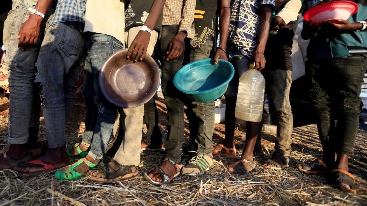 Refugiados etíopes preparam-se para receber comida no campo Um-Rakoba, estado de Al-Qadarif. (Reuters/Mohamed Abdallah)