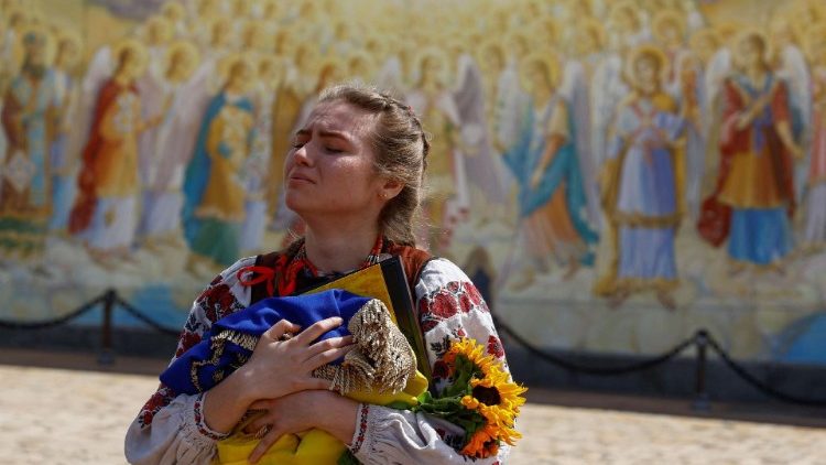 Ivanna Sanina chora enquanto segura uma bandeira nacional ucraniana e um retrato de seu namorado Christopher Campbell, voluntário militar dos EUA da Legião Internacional para a Defesa da Ucrânia, que foi morto em uma luta contra as tropas russas na cidade de Bakhmut, na linha de frente, em meio ao ataque da Rússia ataque à Ucrânia, durante seu funeral em Kiev, Ucrânia, 5 de maio de 2023. REUTERS/Valentyn Ogirenko