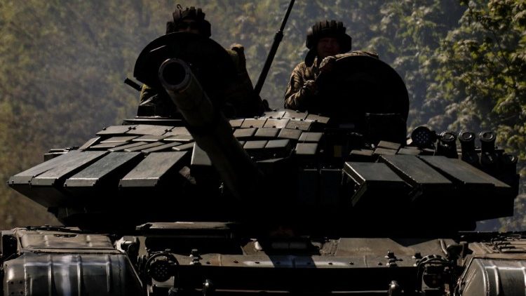 Ukrainian servicemen ride atop of a tank on a road to the frontline town of Bakhmut