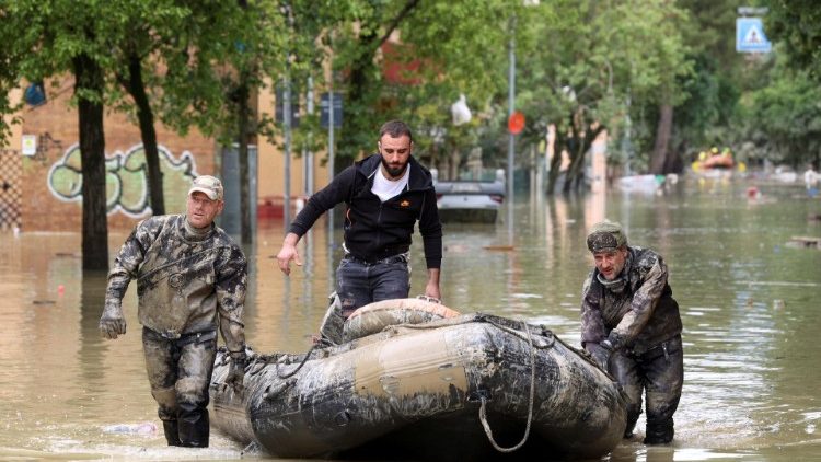 Ufficiali militari assistono una persona su un gommone dopo le forti piogge a Faenza