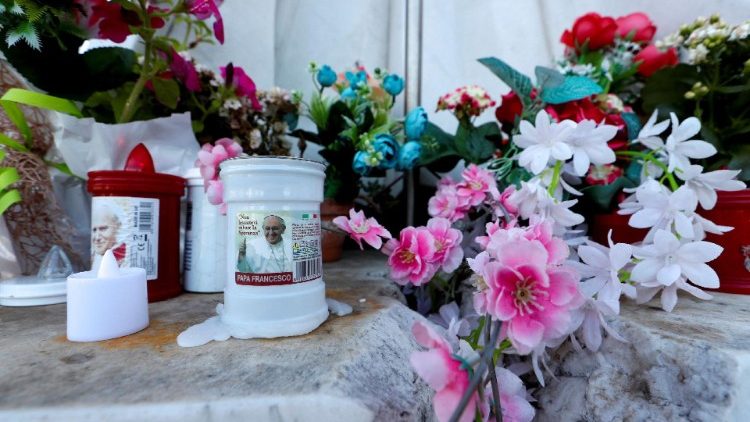 Свічки та квіти біля підніжжя пам'ятника Івану Павлу ІІ при вході до лікарні "Джемеллі"
