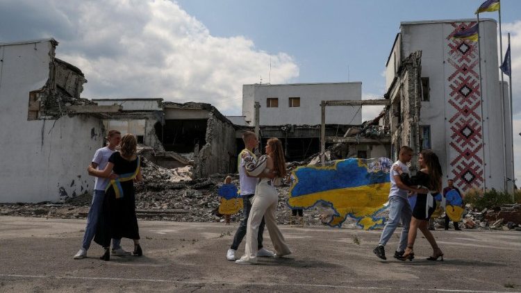 Absolwenci liceum tańczący przed zniszczonym przez rosyjski nalot domem kultury w Dergaczach w obwodzie charkowskim, 17 czerwca 2023
