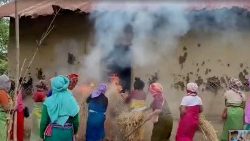 Mulheres colocam feno em chamas na casa do acusado no caso do vídeo viral de Manipur, em Pechi Awang Leikai, Manipur, Índia, 20 de julho de 2023, nesta captura de tela obtida de um vídeo de divulgação. ANI/via REUTERS